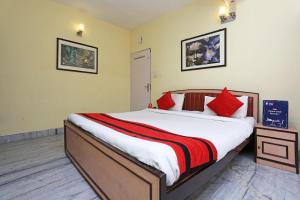 una camera da letto con un grande letto con cuscini rossi di Kalighat a Ālīpur