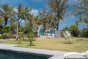 サンジルレバンにあるÔ 3 CAP - Magnifique Villa 8 personnes avec piscine, face à la plage de Boucan-Canotの木々とスイミングプールのある公園の景色を望めます。