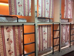 a row of bunk beds in a room with curtains at Stop @Melaka Guesthouse in Melaka