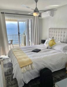 a bedroom with a large bed with a view of the ocean at Shore Break, 1 bedroom apartment in Umdloti