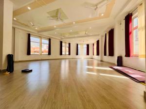 an empty room with a wooden floor and windows at Hotel Amrit Bliss in Rishīkesh