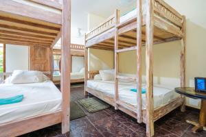 two bunk beds in a room with a desk at Lunar Dive Resort in Tulamben