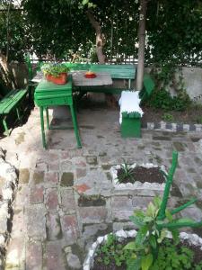 una mesa de picnic verde y un banco en un jardín en Rooms Duran, en Split