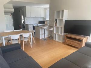 a living room with a couch and a table with a tv at Snowhaven in Jindabyne