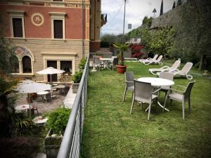 un grupo de mesas y sillas en un patio en Villa Torre - Atmosfera Romantica en Brenzone sul Garda