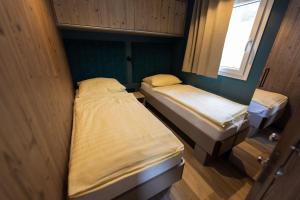 2 camas en una habitación pequeña con ventana en Camping Nord, en Klopein