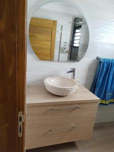 een badkamer met een wastafel en een spiegel bij Chez Monblanc in Saint-Joseph
