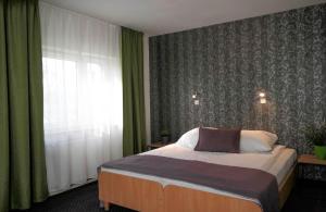 a bedroom with a bed and a large window at Hotel George in Nadarzyn