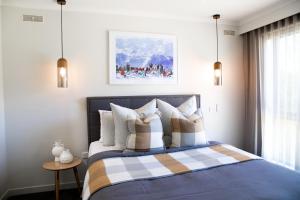 a bedroom with a bed with a checkered blanket at 13 Mountbatten in Bright