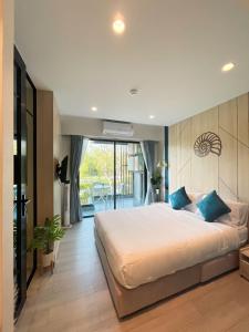 1 dormitorio con 1 cama grande con almohadas azules en Carapace Huahin - Khaotao (ที่พักติดทะเล), en Khao Tao