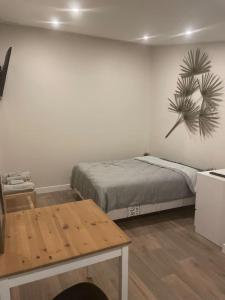 - une chambre avec un lit et une table en bois dans l'établissement Studio indépendant - CDG, Paris,Disney,Astérix, à Arnouville-lès-Gonesse