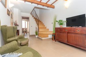 a living room with a television and a staircase at Ses Andrones 3 in Ciutadella