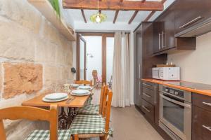 a kitchen with a wooden table and a dining room at Ses Andrones 3 in Ciutadella