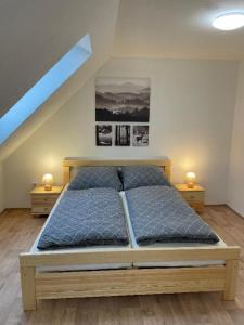 una camera da letto con un grande letto con due comodini di Penzion Star Doksy a Doksy