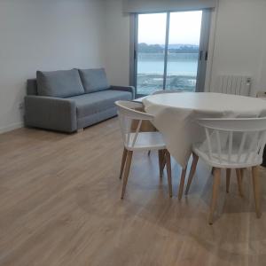 sala de estar con mesa, sillas y sofá en Apartamentos O Grove Awa Bay en O Grove