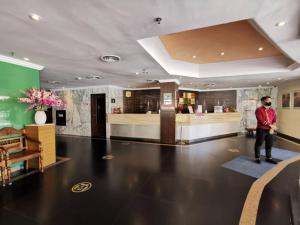 a man standing in the lobby of a hotel at Hotel Capital Kota Kinabalu in Kota Kinabalu