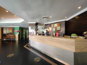 a restaurant with a counter in a lobby at Hotel Capital Kota Kinabalu in Kota Kinabalu