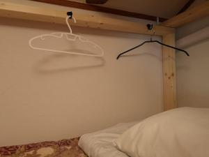 Guest House Himawari - Vacation STAY 32619 في Mine: غرفة نوم مع سرير وحاضنة على الحائط