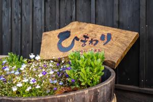 Guest House Himawari - Vacation STAY 32619 في Mine: علامة في وعاء مع الزهور في زرع
