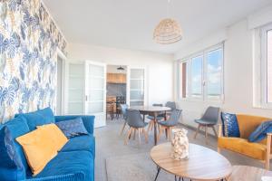 a living room with a blue couch and a table at Banc des Flandres in Bray-Dunes