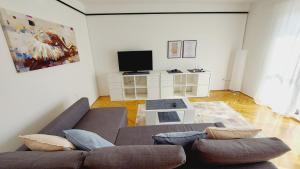 ein Wohnzimmer mit einem Sofa und einem TV in der Unterkunft Apartment with a large terrace, 80 meters from the beach in Pješčana Uvala