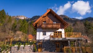 a house with a balcony on top of it at Holiday Mountain House Rupicapra in Kostel