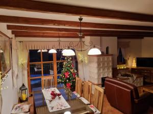 a dining room with a christmas tree and a table at Holiday Mountain House Rupicapra in Kostel