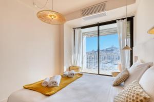 a bedroom with a bed and a large window at La Sentinella - Appt au dessus du Vieux Port in Marseille