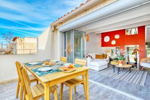 uma sala de jantar e sala de estar com mesa e cadeiras em L'Askoy - Un cabanon d'architecte vue mer em Marselha