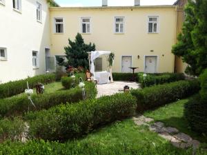 a garden in front of a white house at hotel Memorial in Terezín