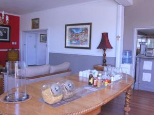 uma sala de estar com uma mesa de madeira com bebidas em The Boston Guest House em Bellville