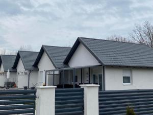 a row of houses with a black roof at Villa LIPI - Home Away from Home in Balatonszemes