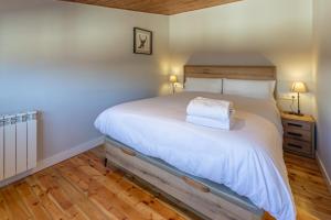 sypialnia z dużym łóżkiem z drewnianym zagłówkiem w obiekcie Apartament l'Avet w mieście Alp