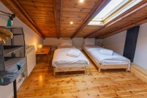 2 łóżka w pokoju z drewnianym sufitem w obiekcie Apartament l'Avet w mieście Alp