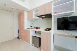 a room with a kitchen with a tv and a counter at RedLiving Apartemen Springlake Summarecon - Novi Rooms Tower Freesia in Rawabugel