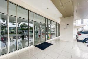 a building with glass windows and a car parked inside at RedLiving Apartemen Springlake Summarecon - Novi Rooms Tower Freesia in Rawabugel