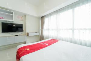 1 dormitorio con 1 cama, TV y ventana en RedLiving Apartemen Springlake Summarecon - Novi Rooms Tower Freesia, en Rawabugel