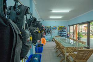 una habitación con una mesa y algunas bolsas colgando en la pared en Lunar Dive Resort: Bamboo Villas en Kubu