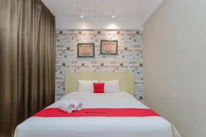 a bedroom with a bed with a dog laying on it at RedDoorz Plus at Riverside Malang in Malang