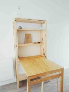 una mesa de madera en una habitación con un estante en Studio dans impasse proche plages Hossegor, en Bénesse-Maremne