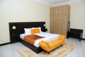 a bedroom with a large bed and a chair at Igwe Home in Kampala