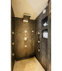 a bathroom with black tiled walls and a shower at ApartmentInCopenhagen Apartment 1529 in Hellerup