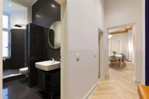 W łazience znajduje się umywalka, toaleta i lustro. w obiekcie Dilo Apartments - Akazien Residenz Apartment & H20 Apartment Berlin "Superior" 160 sqm w Berlinie