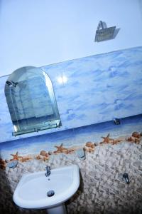 a bathroom with a sink and a mirror at Randu Homestay and Restaurant in Tangalle
