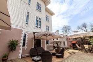 een patio met stoelen en een parasol voor een gebouw bij Lovely Studio in Historic Mansion in Beylerbeyi in Istanbul