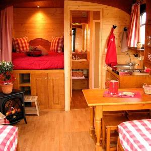 a room with a bed and a table in a cabin at Gite Hôtel chambre d' hôtes et roulottes et du Ternois in Saint-Pol-sur-Ternoise