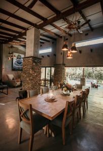 comedor grande con mesa de madera y sillas en Dream of Africa Bush Lodge, en Marloth Park