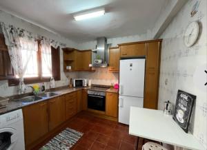 una cucina con armadi in legno e frigorifero bianco di Casa Bella a Bolbaite