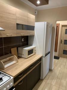 W kuchni znajduje się biała lodówka i kuchenka mikrofalowa. w obiekcie Apartment TT11 w mieście Trnava
