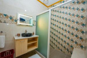 a bathroom with a shower with a sink and a mirror at Paradise Breeze Apartment in Mahe